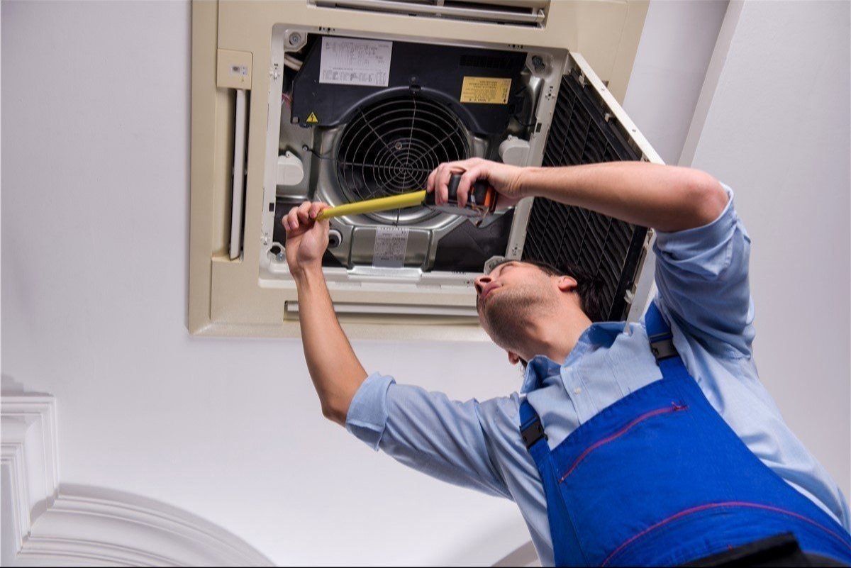 old AC buyers in Begumpet - Phoenix AC Service technician inspecting and repairing AC unit